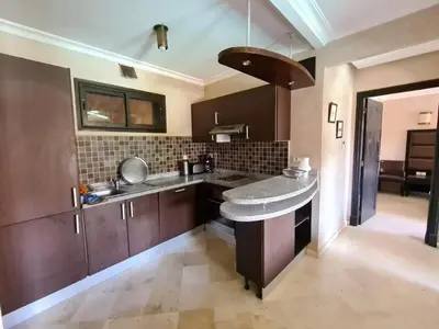 a kitchen with wooden cabinets and a counter top at Palm river marrackech in Marrakech