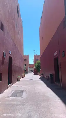an empty alley between two red buildings at Appartement 