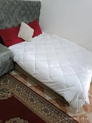 a bed with a white comforter and red pillows at Appartement 