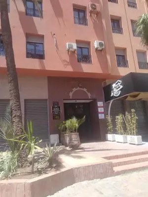 a building with a palm tree in front of it at Guéliz Marrakech 2,central, spacieux, Authentique in Marrakech