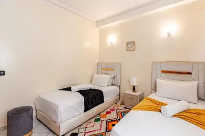 a bedroom with two beds and a rug at Guéliz Marrakech 2,central, spacieux, Authentique in Marrakech