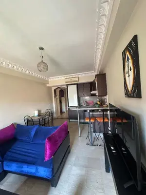 a living room with a blue couch and a kitchen at apartment in the center of Guéliz in Marrakech