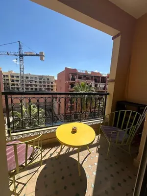 a yellow table and chairs on a balcony with a view at apartment in the center of Guéliz in Marrakech