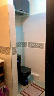 a bathroom with a black toilet in a room at Le Nid de Vacances in Marrakech