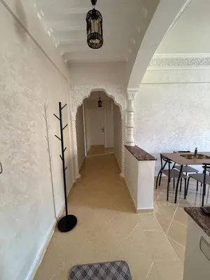 a hallway with a table and a pendant light at Appartement Aeropuerto in Marrakech
