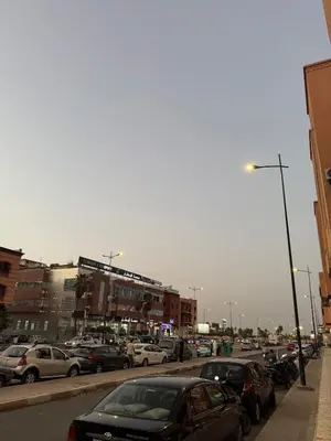 a parking lot filled with parked cars in a city at Appartement Aeropuerto in Marrakech