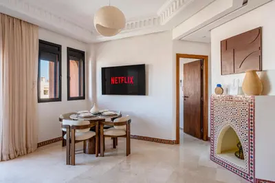 a dining room with a table and a fireplace at Le Berber - Complexe - Piscine - Fitness - Jeux in Marrakech