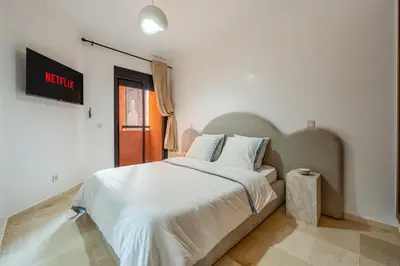 a bedroom with a large bed and a sign on the wall at Le Berber - Complexe - Piscine - Fitness - Jeux in Marrakech