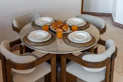 a table with plates of food and glasses of orange juice at Le Berber - Complexe - Piscine - Fitness - Jeux in Marrakech