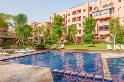 a swimming pool in front of a building at Le Berber - Complexe - Piscine - Fitness - Jeux in Marrakech