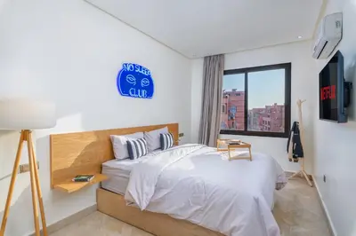 a bedroom with a bed with a blue sign on the wall at -New- Appartement stylé au cœur de Marrakech in Marrakech