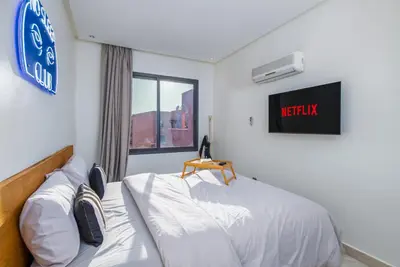 a bedroom with a bed and a sign on the wall at -New- Appartement stylé au cœur de Marrakech in Marrakech
