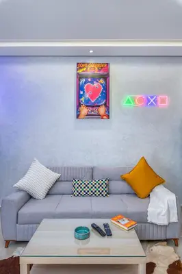 a living room with a gray couch and a painting at -New- Appartement stylé au cœur de Marrakech in Marrakech