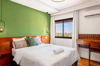 a bedroom with a bed with a green wall at Studio avec piscine et lumières d'ambiance in Marrakech