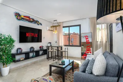a living room with a couch and a tv at Condo in Gueliz inspired by motorsports in Marrakech