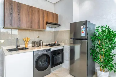 a kitchen with a washing machine and a refrigerator at Condo in Gueliz inspired by motorsports in Marrakech
