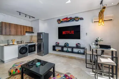 a living room with a tv on a wall at Condo in Gueliz inspired by motorsports in Marrakech