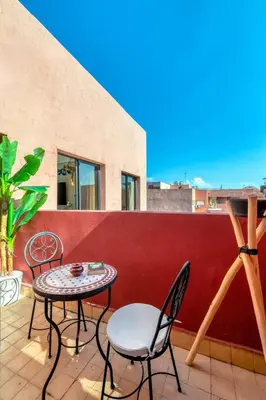 a patio with two chairs and a table on a roof at Condo in Gueliz inspired by motorsports in Marrakech