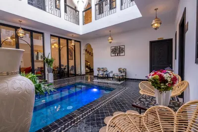 a villa with a swimming pool and a living room at Riad Sahelia in Marrakech