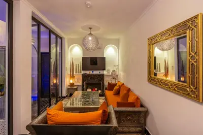 a living room with orange furniture and a mirror at Riad Sahelia in Marrakech