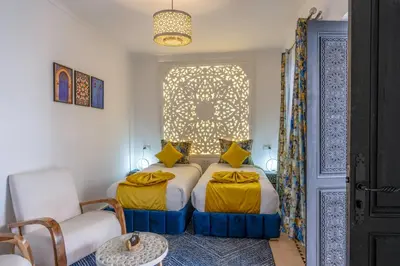 a bedroom with two beds and a window at Riad Sahelia in Marrakech