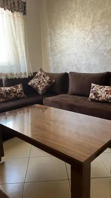 a brown couch with pillows on it in a living room at Appartement Marrakech au 1er étage in Marrakech