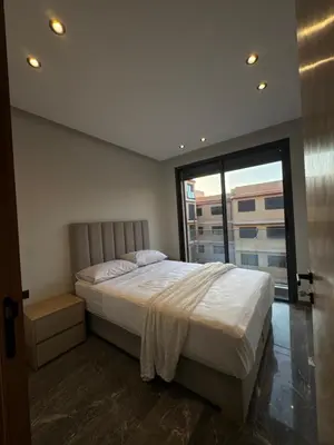 a bedroom with a large bed and a large window at Appartement Gueliz Elite garden in Marrakech