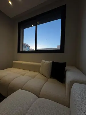a bedroom with a large couch in front of a window at Appartement Gueliz Elite garden in Marrakech