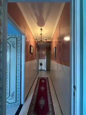 a hallway with a red rug on the floor and a chandelier at Appartement Layane Votre havre de paix à deux pas de Guéliz in Marrakech