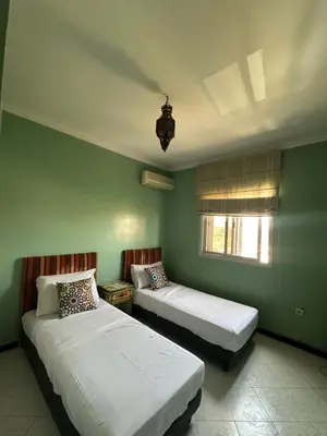 two beds in a room with green walls at Appartement Layane Votre havre de paix à deux pas de Guéliz in Marrakech
