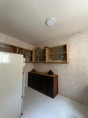 a kitchen with a refrigerator and a tiled wall at Appartement Layane Votre havre de paix à deux pas de Guéliz in Marrakech