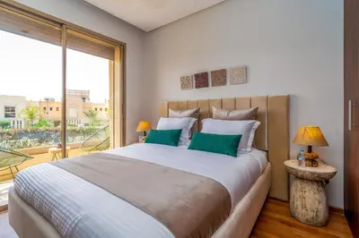 a bedroom with a large bed with green pillows at Chic & Cozy Apartment with Pool View - Prestigia in Marrakech