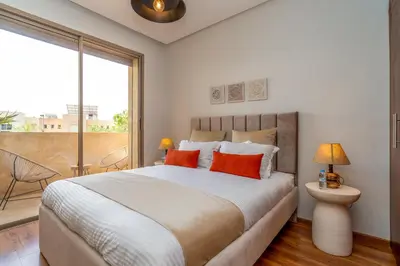 a bedroom with a large bed with orange pillows at Chic & Cozy Apartment with Pool View - Prestigia in Marrakech
