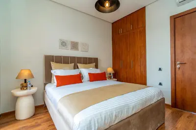 a bedroom with a large bed with red pillows at Chic & Cozy Apartment with Pool View - Prestigia in Marrakech