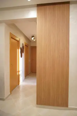 a hallway with a wooden wall in a building at New cozy 2 bedroom apartment with 3 ACs close to airport and center in Marrakech