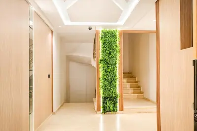 a vertical green wall in a hallway with stairs at Appartement LA 17 in Marrakech