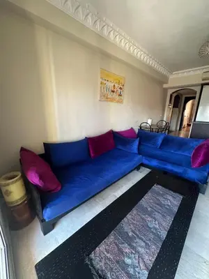 a blue couch with red pillows in a living room at Apartement in the centre in Marrakech