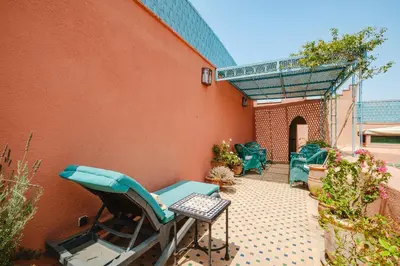 a patio with chairs and a table and a building at Riad Alzira Jardin Secret Au coeur De La Medina in Marrakech