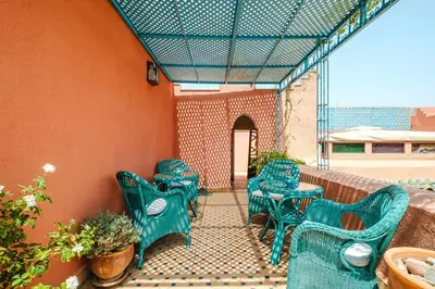 a group of green chairs and tables on a patio at Riad Alzira Jardin Secret Au coeur De La Medina in Marrakech