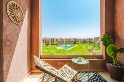 a balcony with a table and chairs and a window at Appartement de charme residence avec piscine WiFi in Marrakech