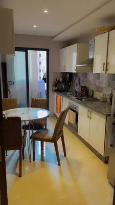 a kitchen with a table and a table and chairs at jnane ali akioud Gueliz in Marrakech