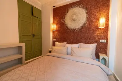 a bedroom with a bed and a wall at Riad Médina Bienvenue in Marrakech