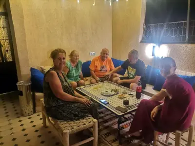 a group of people sitting around a table playing chess at Riad Médina Bienvenue in Marrakech