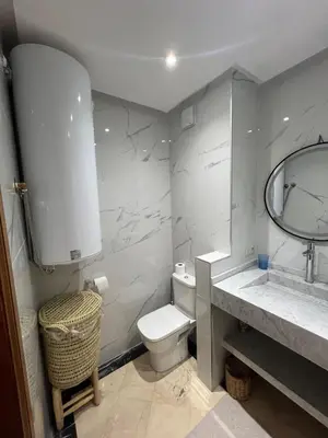 a bathroom with a toilet and a sink and a mirror at Élégance & fraîcheur Appart avec piscine in Marrakech