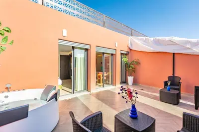a room with a tub and chairs and a building at AYLAL Marrakech in Marrakech
