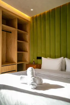 a bedroom with a white bed with green walls at AYLAL Marrakech in Marrakech