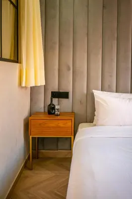 a bedroom with a bed and a table with a lamp at AYLAL Marrakech in Marrakech