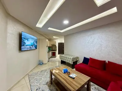 a living room with a red couch and a table at Cozy & calm apartment in Marrakech