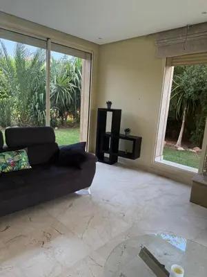 a living room with a black couch and a tv at Villa argan in Marrakech