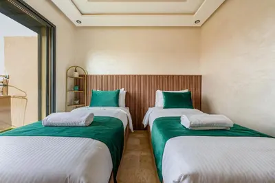 two beds in a room with green and white at Chic 2BR apartment wifi balcon in Marrakech